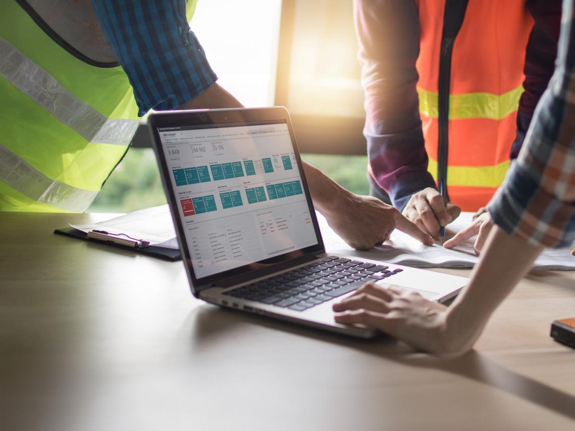Des ouvriers de chantier utilisent ERP BTP sur leur ordinateur